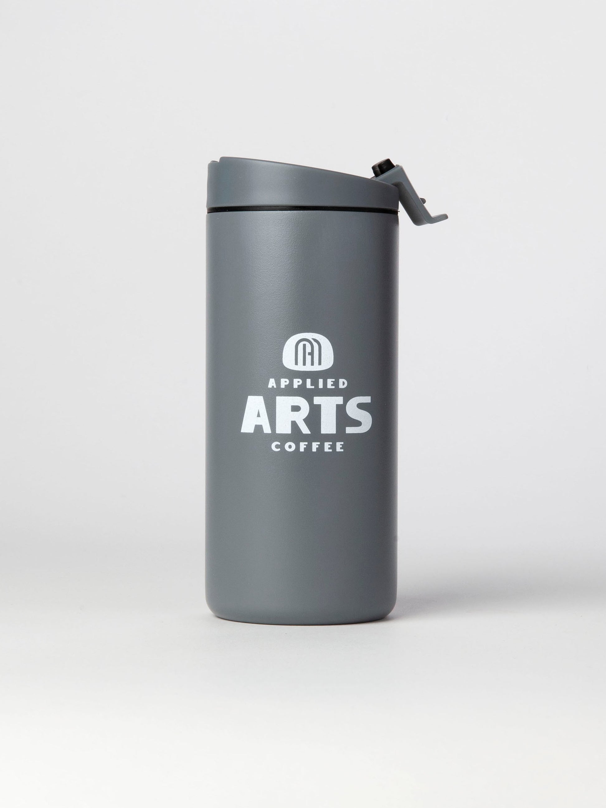 Miir 12oz Flip Traveler in Basal (grey inspred by the marine mist of the pacific northwest) with Applied Arts Coffee logo in White, photographed on a white background.